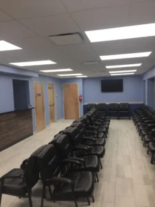 Commercial interior renovation featuring a professional waiting area with seating, modern lighting, tiled floors, and reception counter.