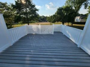 Custom-built composite deck with white vinyl railing, designed for outdoor living and backyard entertaining